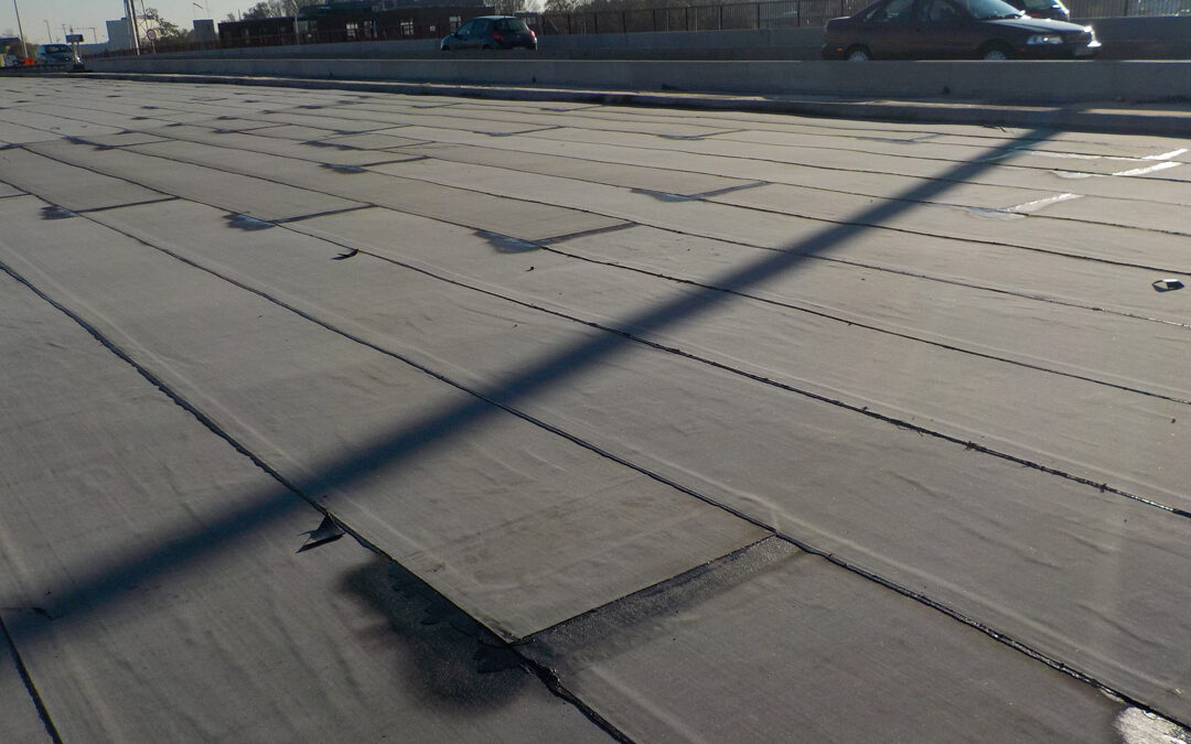 Pose machinalement d’une membrane bitumineuse (roofing) sur le tablier d’un pont à Deinze pour Willemen Infra